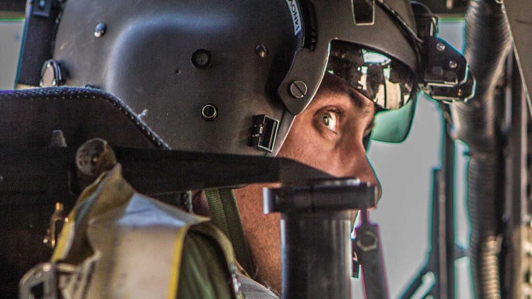 A soldier looks around as he prepares to take off in a helicopter.