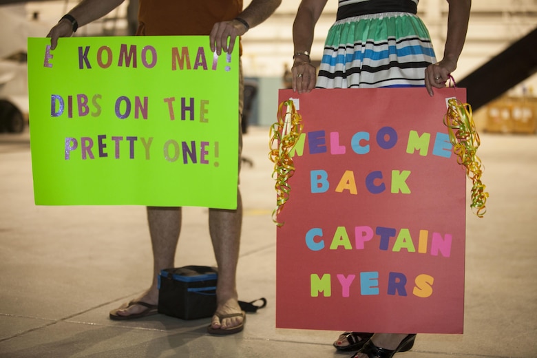 Family members hold signs for loved ones from Marine Medium Tiltrotor Squadron (VMM) 268, nicknamed the “Red Dragons,” after completing a trans-Pacific flight from Australia, Marine Corps Base Hawaii (MCBH), Sept. 19, 2017. The “Red Dragons” supported the Australian Defence Force as the aviation combat element for the Marine Air-Ground Task Force (MAGTF) with Marine Rotational Force Darwin (MRF-D), Australia. These are the first Trans-Pacific flights the MV-22 Ospreys have conducted from Hawaii to Australia. This movement demonstrates that the unfueled range of our MV-22s combined with our refueling capabilities allow us to reach across the entire Pacific Ocean. The U.S. Marine Corps can get it's aircraft and personnel to a crisis on the other side of the world in a matter of days. (U.S. Marine Corps photo by Cpl. Jesus Sepulveda Torres)