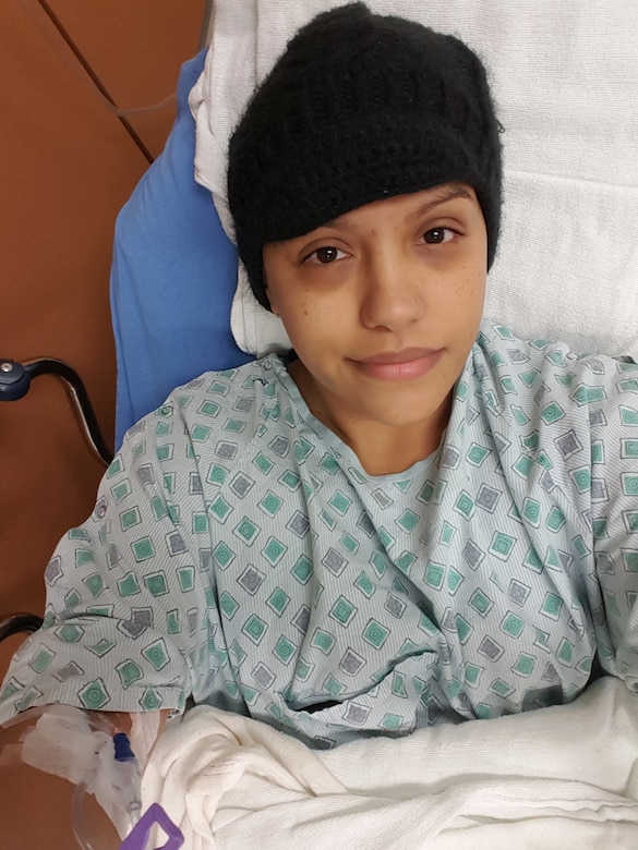 Staff Sgt. Teresa Monteon, 60th Medical Group training manager from San Jose, Calif., sits in her hospital bed during a nine-day hospitalization at David Grant USAF Medical Center in December 2016. Monteon was diagnosed with Hodgkin’s Lymphoma and is now in remission after undergoing four months of chemotherapy and one month of proton therapy. (Courtesy Photo)