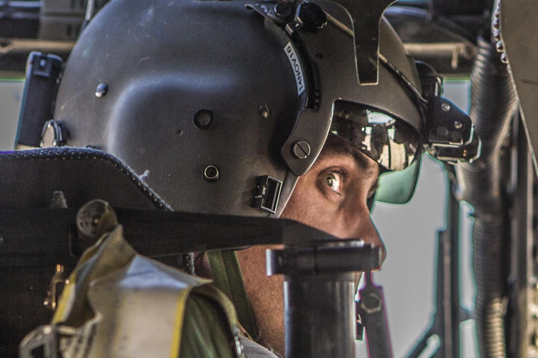 A soldier looks around as he prepares to take off in a helicopter.