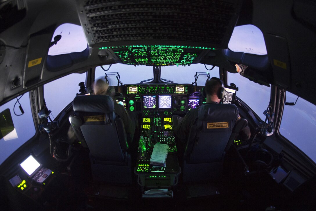 Air Force Maj. Kari Fleming, left, and Royal air force flight Lt. Matt Jenkinson fly a C-17 Globemaster III aircraft over the U.S. Virgin Islands.