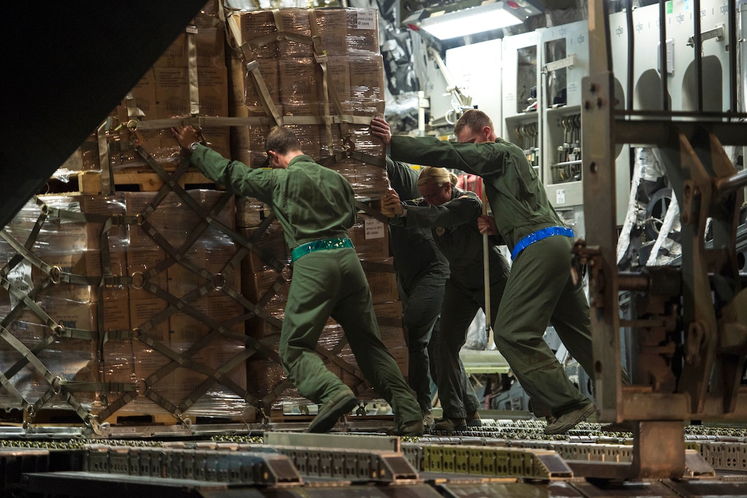 Airmen push a pallet of water off from a C-17 Globemaster III aircraft on St. Croix.