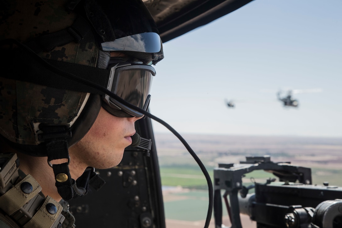 U.S. Marine Corps Cpl. Christopher Madere, crew chief, with Marine Light Attack Helicopter Squadron 469 (HMLA-469) assess targets during an aerial gunnery refinement drill in support of Weapons and Tactics Instructor course (WTI) 1-18 at Chocolate Mountain, Aerial Gunnery Range, Calif., Sept 25, 2017. WTI is a seven week training event hosted by Marine Aviation Weapons and Tactics Squadron One (MAWTS-1) cadre which emphasizes operational integration of the six functions of Marine Corps Aviation in support of a Marine Air Ground Task Force and provides standardized advanced tactical training and certification of unit instructor qualifications to support Marine Aviation Training and Readiness and assists in developing and employing aviation weapons and tactics. (U.S. Marine Corps photo by Sgt. Allison Lotz)