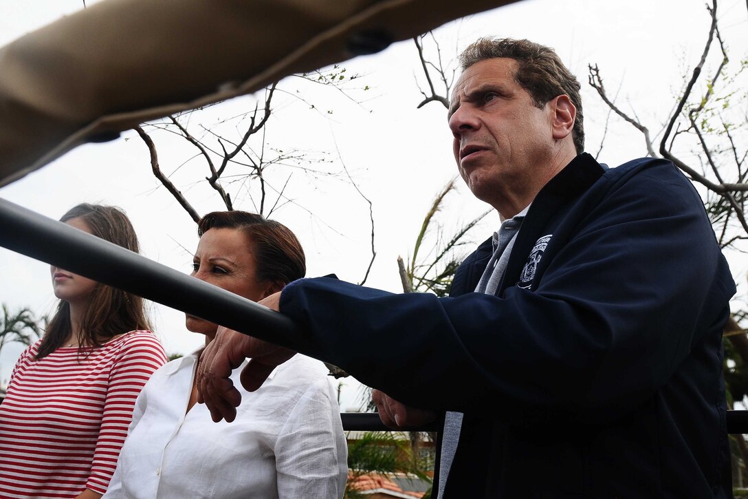 Officials look at damaged areas after a hurricane.