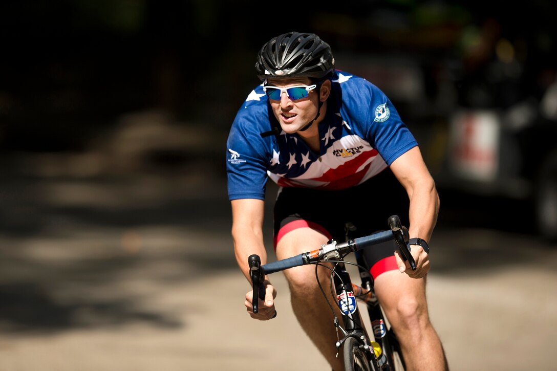 Marine Corps Cpl. Gabriel Gehr races a bicycle during Invictus Games 2017.