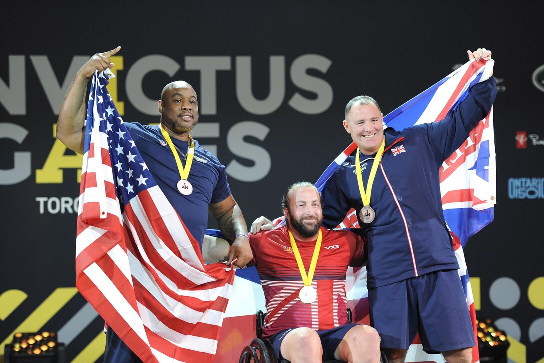 The men's heavyweight powerlifting competition finalists pose for a photograph after a medal ceremony.