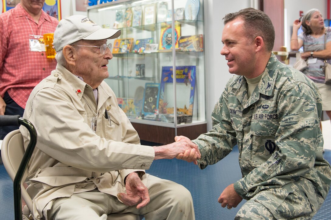 Col. Walt Jackim, 45th Space Wing vice commander, receives a coin from Frank Losonsky, the sole remaining member of the American Volunteer Group Flying Tigers during a visit to Cape Canaveral Air Force Station, Fla. on Sept. 21, 2017. Losonsky and 50 descendants of the original members, toured the Cape and learned how the Flying Tigers and the 45th Space Wing share a distinct lineage as subordinate units of the 14th Air Force. From P-40 Warhawk aircraft to launching rockets into space, 14th Air Force units have been breaking barriers for many decades.