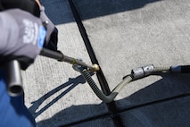 A German contractor adjusts his tools to inject tar in the drains of Ramp 5 on Ramstein Air Base, Germany Sept 21, 2017. This special tool is able to fit between the smallest cracks to apply the heated tar on the flightline. (U.S. Air Force photo by Airman 1st Class Milton Jr. Hamilton)