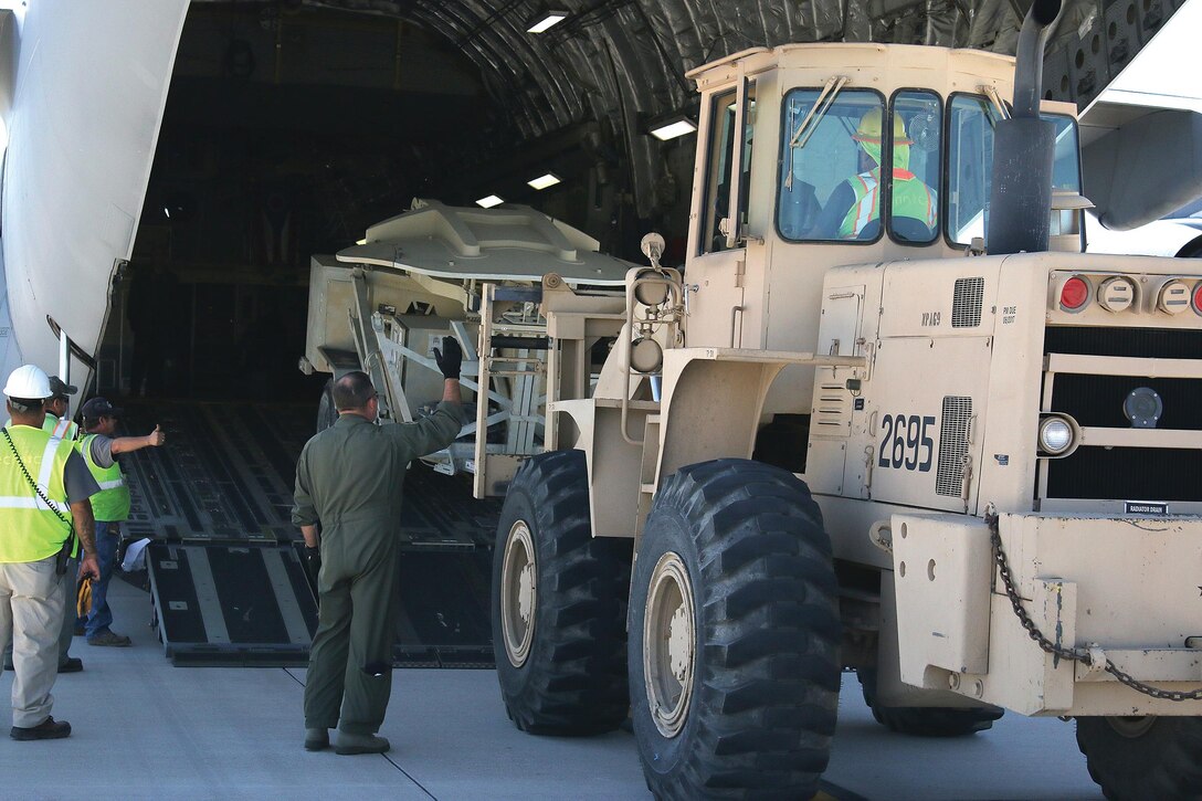 Chief Master Sgt. Jason LeMaster, 89th Airlift Squadron loadmaster, spots a forklift being loaded into the cargo area of a 445th Airlift Wing C-17 Globemaster III aircraft at Biggs Army Field in El Paso, Texas, for transport to aid in Hurricane Harvey relief efforts Aug. 30, 2017. (U.S. Air Force photo/Master Sgt. Patrick O'Reilly)