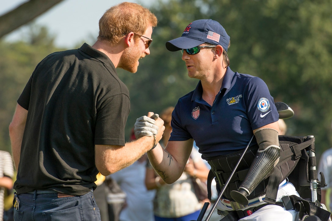 Marine Corps veteran Sgt. Michael Nicholson is congratulated by Britain's Prince Harry after a remarkable drive on the 16th tee.
