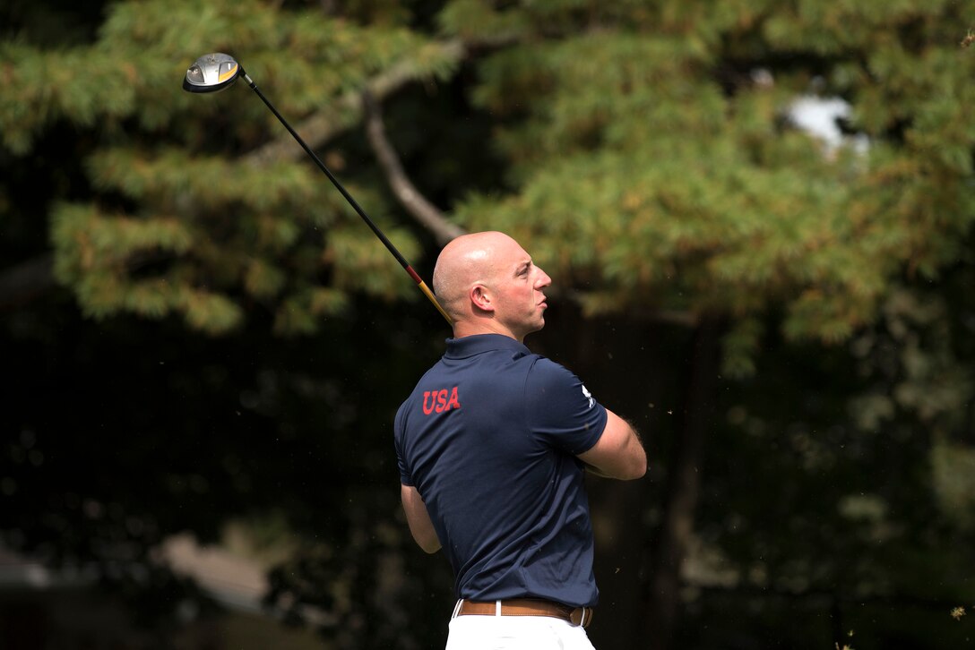 Marine Corps Gunnery Sgt. Matthew Branch hits a tee shot competing in golf.