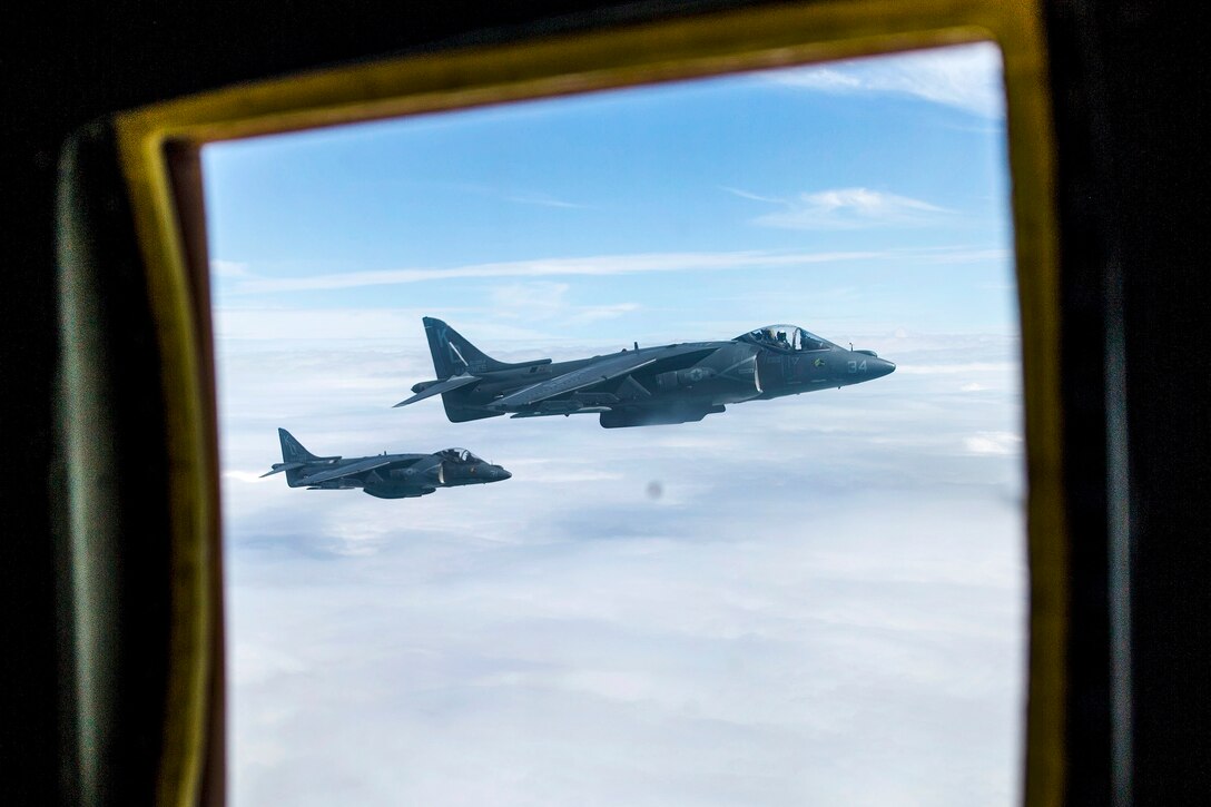As seen through the window of an aircraft, two other aircraft are in flight.