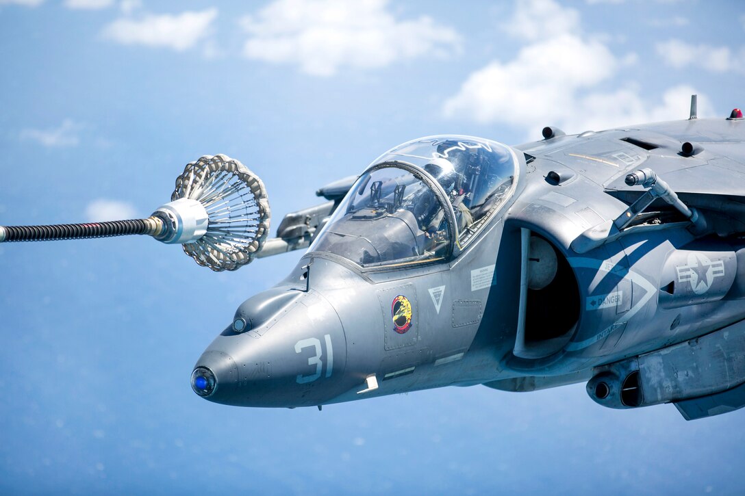 A Marine Corps AV-8B Harrier prepares to receive fuel from a KC-130J Super Hercules aircraft during an aerial refueling training.