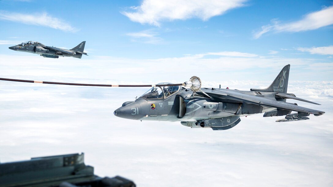 A Marine Corps AV-8B Harrier receives fuel from a KC-130J Super Hercules aircraft during an aerial refueling training.