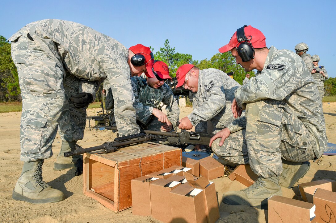 Guardsmen inspect a M240B machine gun before being used during heavy weapons training.