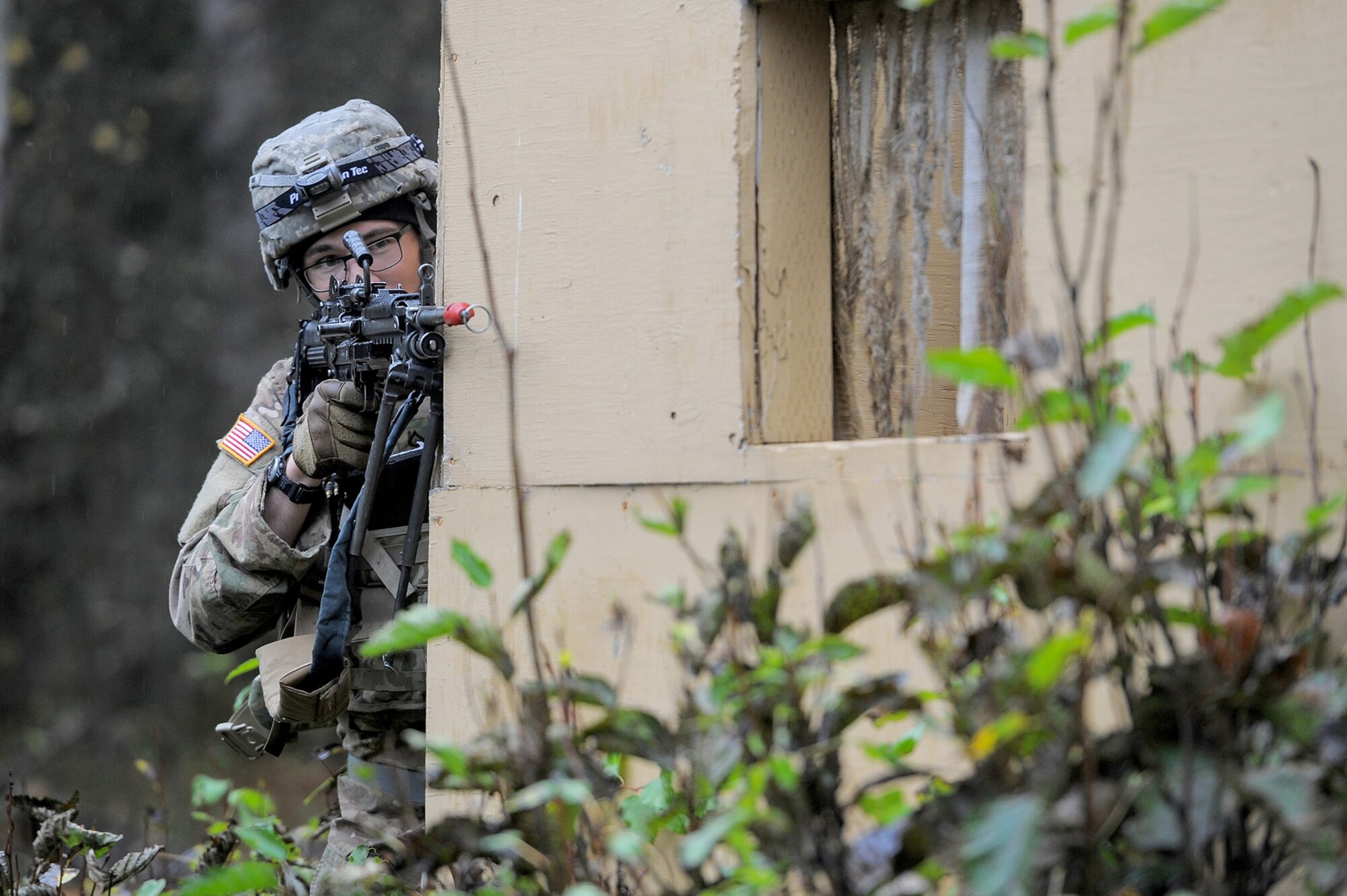 Army Pfc. James Corbin, assigned to the 109th Transportation Company "Muleskinners", 17th Combat Sustainment Support Battalion, U.S. Army Alaska, covers fellow Soldiers as they maneuver through a mock village during an exercise on Joint Base Elmendorf-Richardson, Alaska, Sept. 21, 2017.  The Soldiers performed this training as part of a larger exercise in multiple locations to build and maintain proficiency in essential soldiering skills like react to contact, and securing an objective as well as traffic control point training.