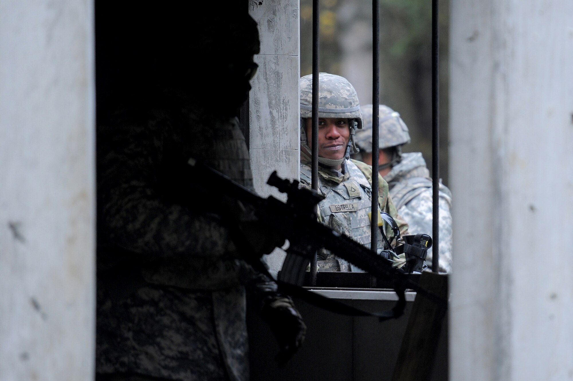 Army Pfc. Nathaniel Estrella, assigned to the 109th Transportation Company "Muleskinners", 17th Combat Sustainment Support Battalion, U.S. Army Alaska, looks through a window as fellow Soldiers clear a building during an exercise on Joint Base Elmendorf-Richardson, Alaska, Sept. 21, 2017.  The Soldiers performed this training as part of a larger exercise in multiple locations to build and maintain proficiency in essential soldiering skills like react to contact, and securing an objective as well as traffic control point training.