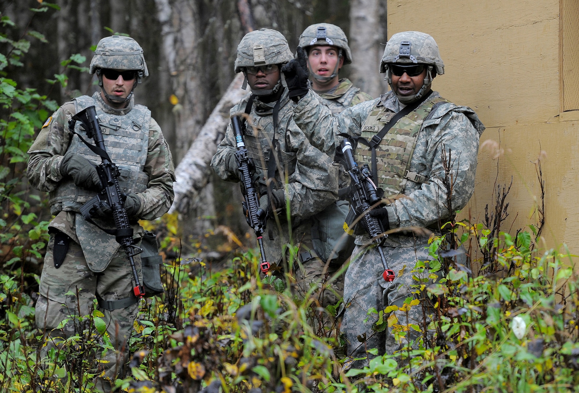 Army Staff Sgt. Xavier Brooks, assigned to the 109th Transportation Company "Muleskinners", 17th Combat Sustainment Support Battalion, U.S. Army Alaska, issues orders to his Soldiers while securing an objective during an exercise on Joint Base Elmendorf-Richardson, Alaska, Sept. 21, 2017.  The Soldiers performed this training as part of a larger exercise in multiple locations to build and maintain proficiency in essential soldiering skills like react to contact, and securing an objective as well as traffic control point training.