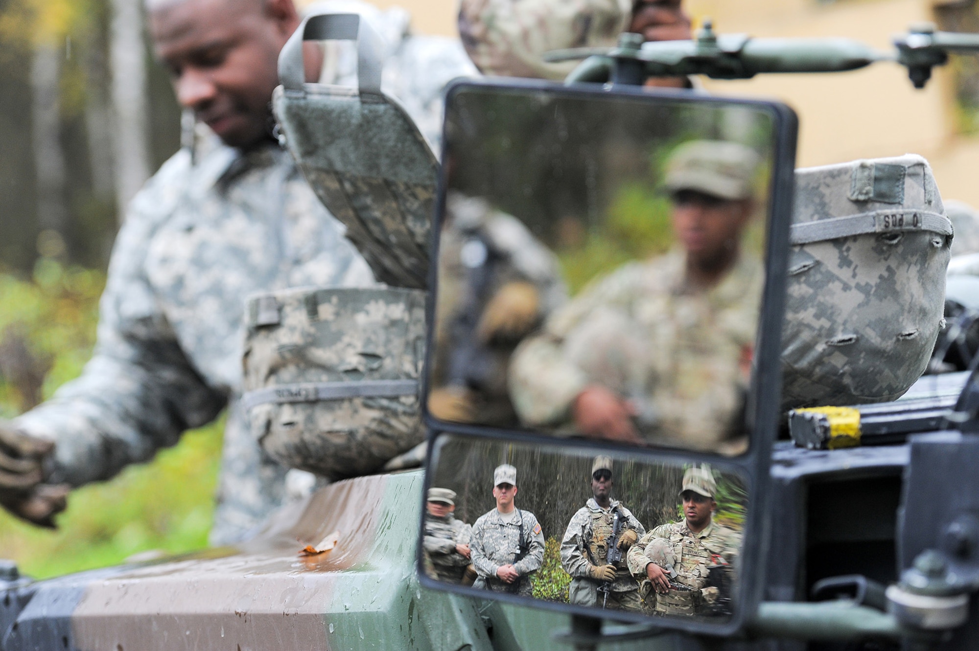 Soldiers assigned to the 109th Transportation Company "Muleskinners", 17th Combat Sustainment Support Battalion, U.S. Army Alaska, are seen in the mirror of a military vehicle as they receive instruction on traffic control point procedures on Joint Base Elmendorf-Richardson, Alaska, Sept. 21, 2017.  The Soldiers performed this training as part of a larger exercise in multiple locations to build, and maintain proficiency in essential soldiering skills.