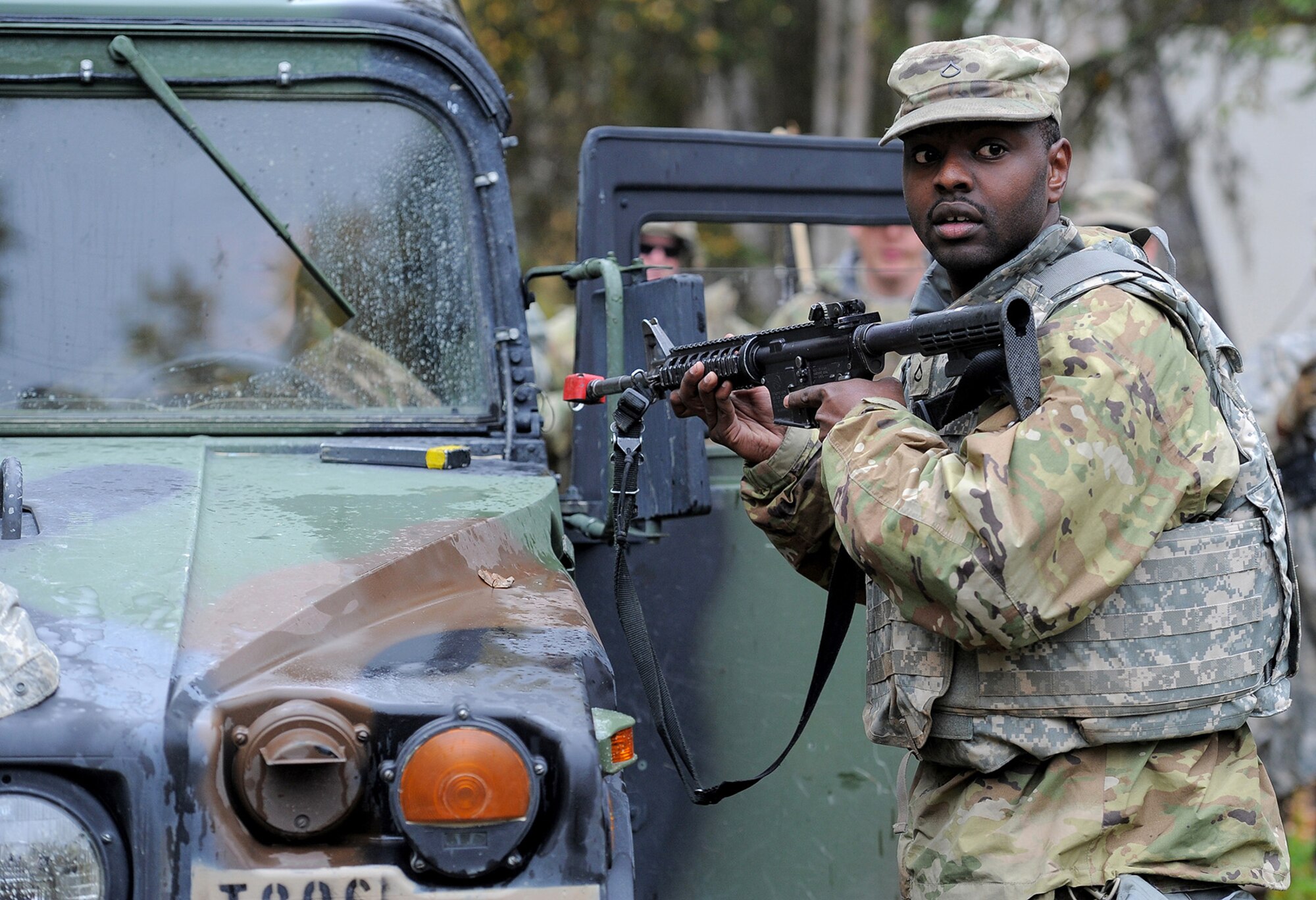 Army Pfc. Randy Zakayo, assigned to the 109th Transportation Company "Muleskinners", 17th Combat Sustainment Support Battalion, U.S. Army Alaska, looks over his shoulder as he receives instruction during traffic control point training on Joint Base Elmendorf-Richardson, Alaska, Sept. 21, 2017.  The Soldiers performed this training as part of a larger exercise in multiple locations to build, and maintain proficiency in essential soldiering skills.