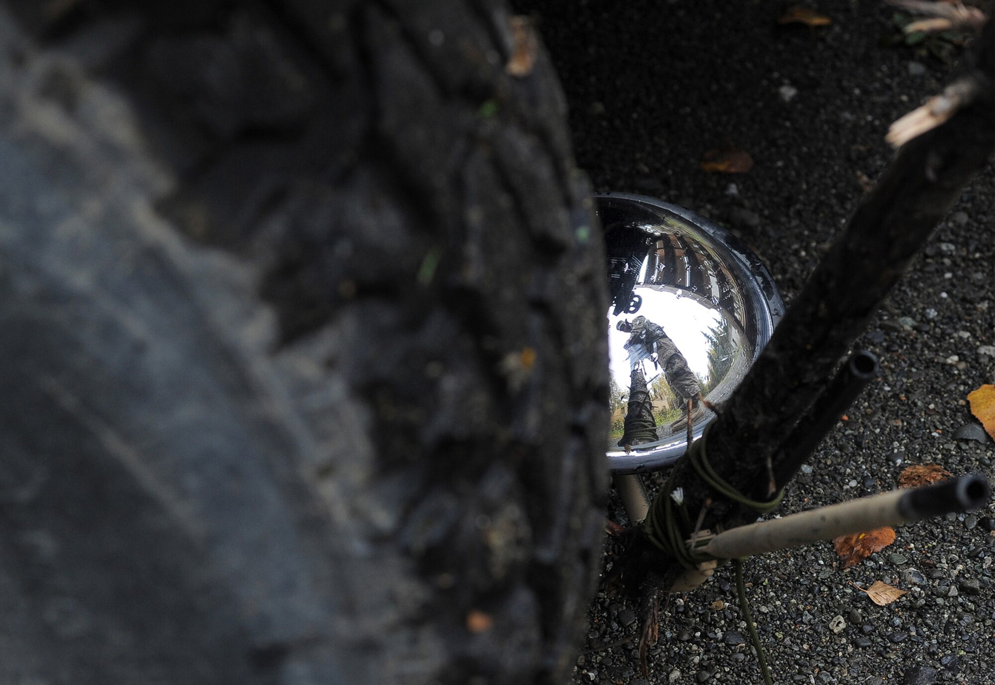 A soldier assigned to the 109th Transportation Company "Muleskinners", 17th Combat Sustainment Support Battalion, U.S. Army Alaska, uses a mirror to inspect the underside of a vehicle during traffic control point training on Joint Base Elmendorf-Richardson, Alaska, Sept. 21, 2017.  The Soldiers performed this training as part of a larger exercise in multiple locations to build, and maintain proficiency in essential soldiering skills