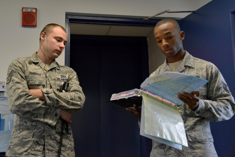 (From left) U.S. Air Force Staff Sgt. Joshua Shaffer, 1st Operations Support Squadron tower watch supervisor, and Senior Airman Richard Smith, 1st OSS air traffic controller, brief their crew before starting the evening shift at Joint Base Langley-Eustis, Va., Sept. 26, 2017.