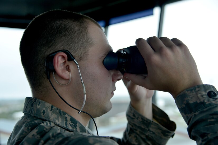 U.S. Air Force Staff Sgt. Joshua Shaffer, 1st Operations Support Squadron tower watch supervisor, performs a visual check to make sure the air space is clear of birds at Joint Base Langley-Eustis, Va., Sept. 26, 2017.