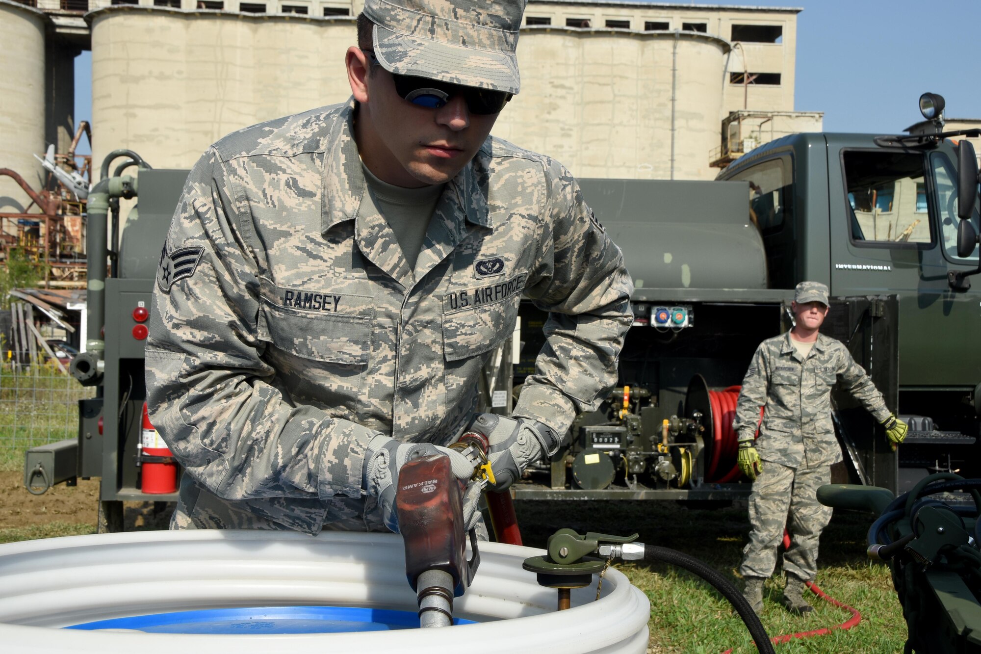 Senior Airman John Ramsey VI loads fuel into a barrel to power a generator as Staff Sgt. Levi Wiskirchen, both from the 269th Combat Communications Squadron, Springfield Air National Guard base, regulates the flow of diesel fuel at the Tech Warrior 2017 exercise, at the National Center for Medical Readiness, Fairborn, Ohio Sept. 21, 2017. The 269 CBCS provided power, air conditioning and land mobile radio support for the 10-day exercise