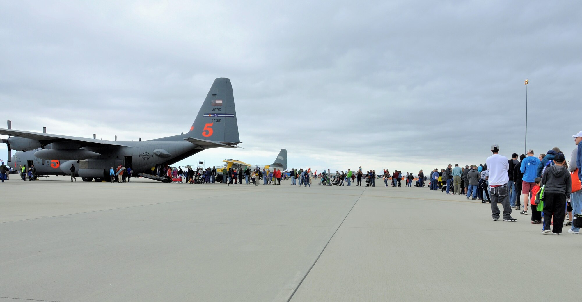 A line of attendees at the the Pikes Peak Regional Airshow extends behind an Air Force Reserve Command C-130 Hercules aircraft Sept. 23, 2017, at the Colorado Springs Airport, Colo