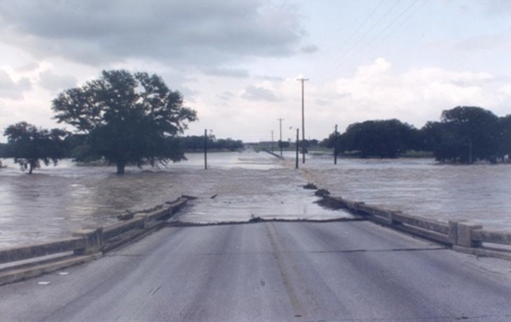 Floodwaters flow across Kelly Street during a heavy downpour at Joint Base San Antonio-Lackland in 2012. Authorities at all base communities monitored weather conditions 24-hours a day and were ready to put up barriers and "Street Closed" signs to prevent motorists from crossing the affected areas.