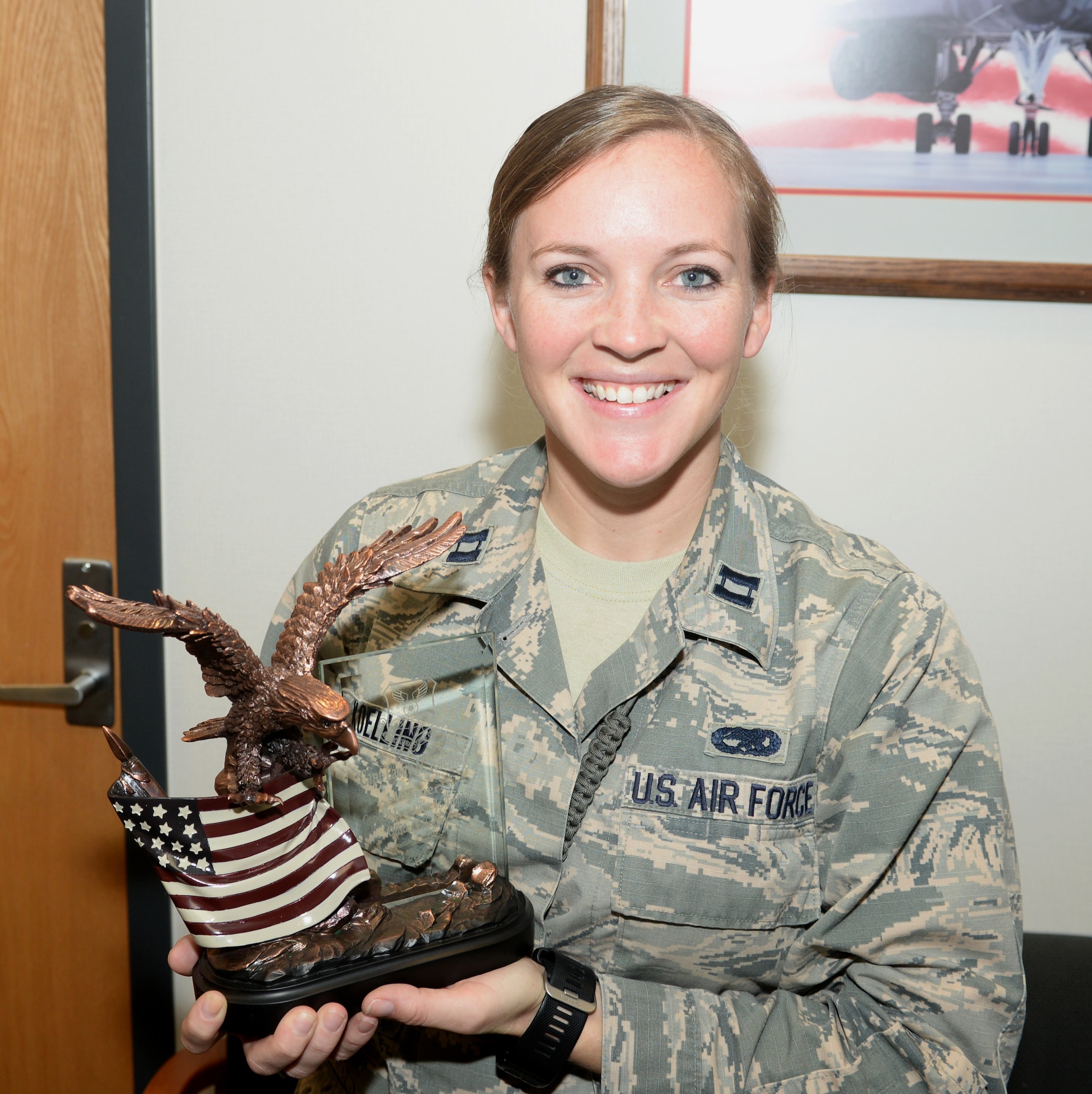 Capt. Lacey Koelling, officer in charge of the 34th Aircraft Maintenance Unit, stands with the General Lew Allen, Jr., Trophy Ellsworth Air Force Base, S.D., Sept. 26, 2017. Koelling and her team earned the award for their outstanding actions in sortie generations and leadership at Al-Dhafra Air Base in the United Arab Emirates. (U.S. Air Force photo by Airman 1st Class Thomas Karol)