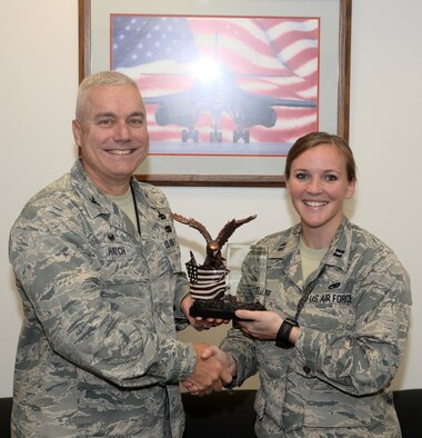 Capt. Lacey Koelling, officer in charge of the 34th Aircraft Maintenance Unit, and Col. Bernard J. Hatch III, the commander of the 28th Maintenance Group, hold the General Lew Allen, Jr., Trophy which was presented to Koelling at Ellsworth Air Force Base, S.D., Sept. 26, 2017. Koelling earned the award for her actions during her deployment to Al-Dhafra Air Base in the United Arab Emirates. (U.S. Air Force photo by Airman 1st Class Thomas Karol)