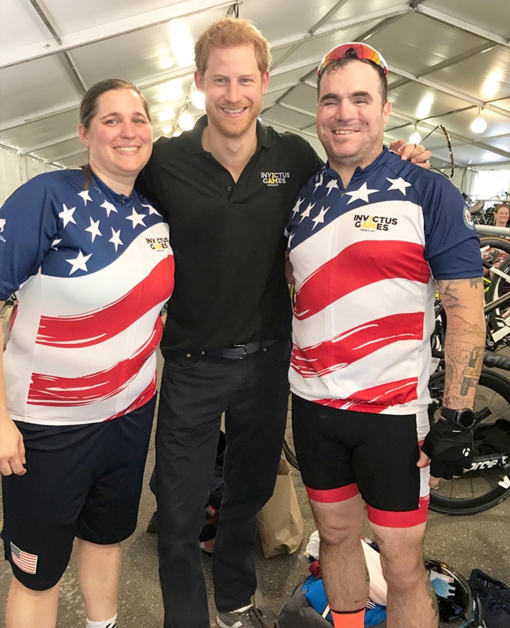 U.S. Air Force veteran Kyle Burnett, a former knowledge operations master sergeant, and U.S. Air Force veteran Reese Hines, a former explosive ordnance disposal master sergeant, stand with Prince Harry of Wales following a meet and greet during the cycling competition of the 2017 Invictus Games in Toronto, Canada, Sept. 26, 2017. Prince Harry took a moment to meet the couple, while learning more about their stories and journey to Invictus. (Courtesy photo)