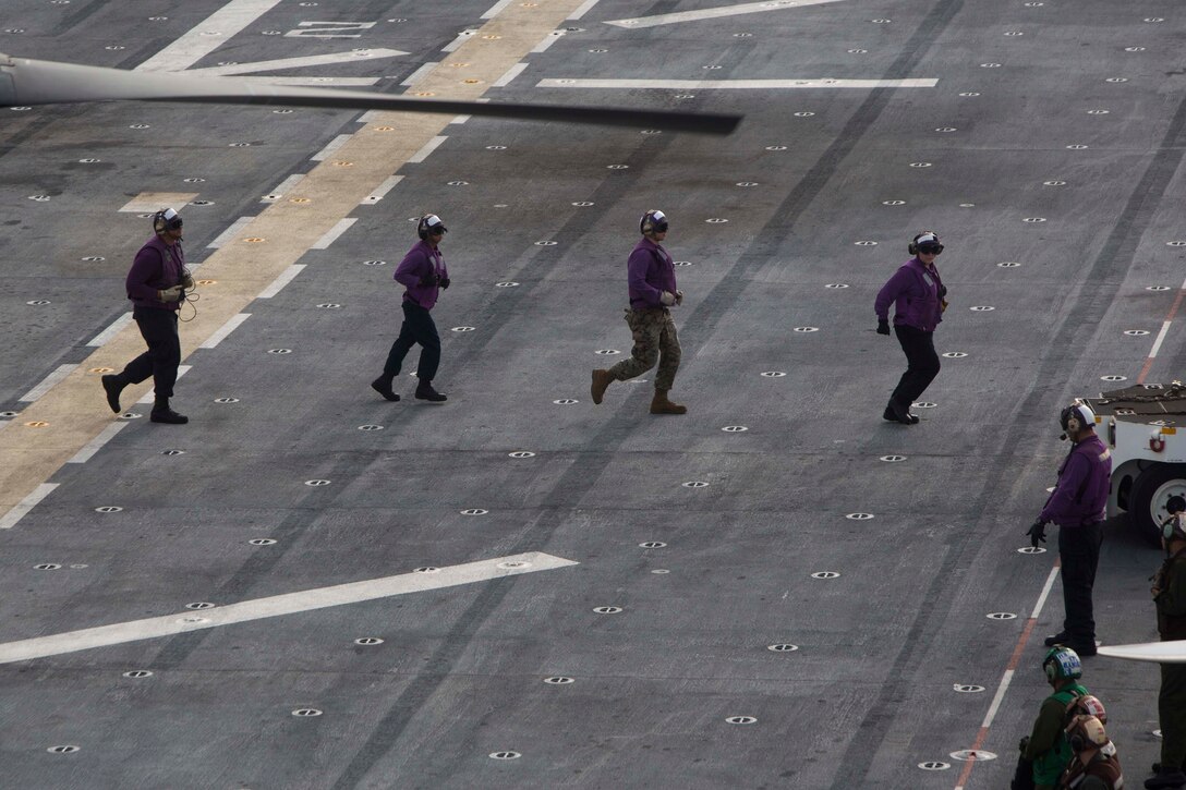 U.S Navy Sailors assigned to the amphibious assault ship USS Kearsarge (LHD 3) and a Marine with the 26th Marine Expeditionary Unit (MEU) clear the flight deck as aircraft prepared to take off in support of Hurricane Maria relief efforts in the Caribbean Sea, Sept. 27, 2017.  The 26th MEU is supporting Federal Emergency Management Agency, the lead federal agency, in helping those affected by Hurricane Maria to minimize suffering and is one component of the overall whole-of-government response effort. (U.S. Marine Corps photo by Cpl. Juan A. Soto-Delgado)