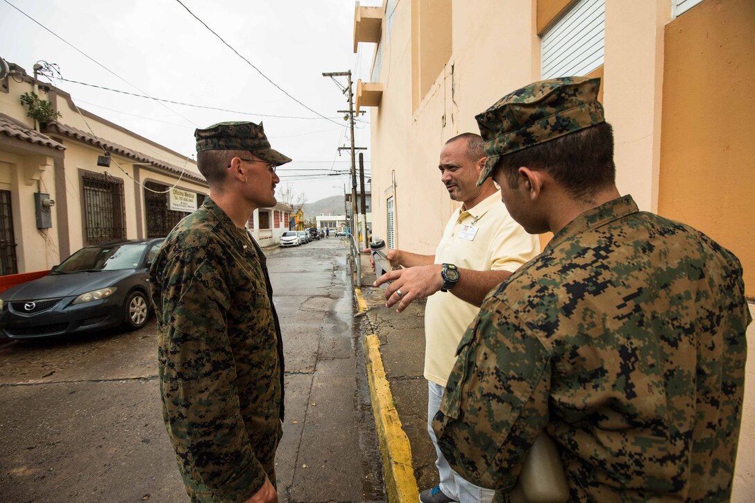 U.S. Marine 1st Lt. Charles V. McCole, left, an officer with the Air Traffic Control Mobile Team, 26th Marine Expeditionary Unit (MEU), and Navy Hospitalman Apprentice Judd A. Ostolaza, right, a local resident and reservist with Detachment 1, Headquarters & Services Company, 4th Marine Logistics Group (MLG), volunteering his translating services with the 26th MEU, speak with a local resident during an assessment of Humacao Hospital’s medical and operational needs as part of Hurricane Maria relief efforts at Humacao, Puerto Rico, Sept. 27, 2017. The 26th MEU is supporting the Federal Emergency Management Agency, the lead federal agency, and local authorities in Puerto Rico with the combined goal of protecting the lives and safety of those in affected areas. (U.S. Marine Corps photo by Lance Cpl. Tojyea G. Matally)