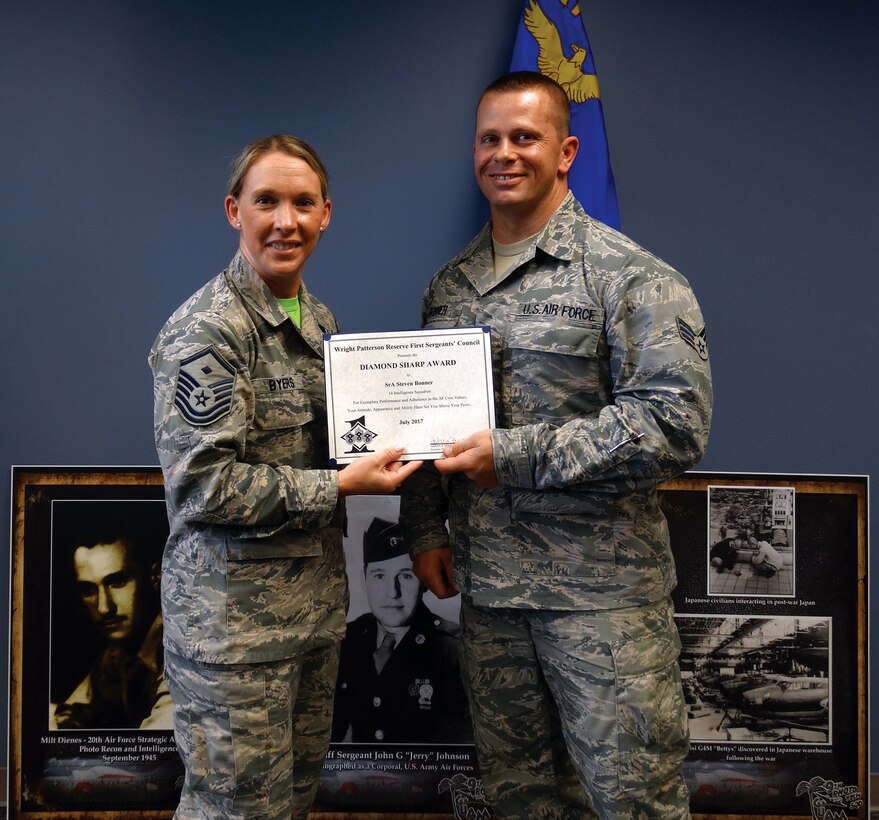 Master Sgt. Ashley Byers, 64th Intelligence Squadron first sergeant, presents the July 2017 Diamond Sharp Award to Senior Airman Steven Bonner, 14th Intelligence Squadron, during the Sept. 23, 2017 unit training assembly.