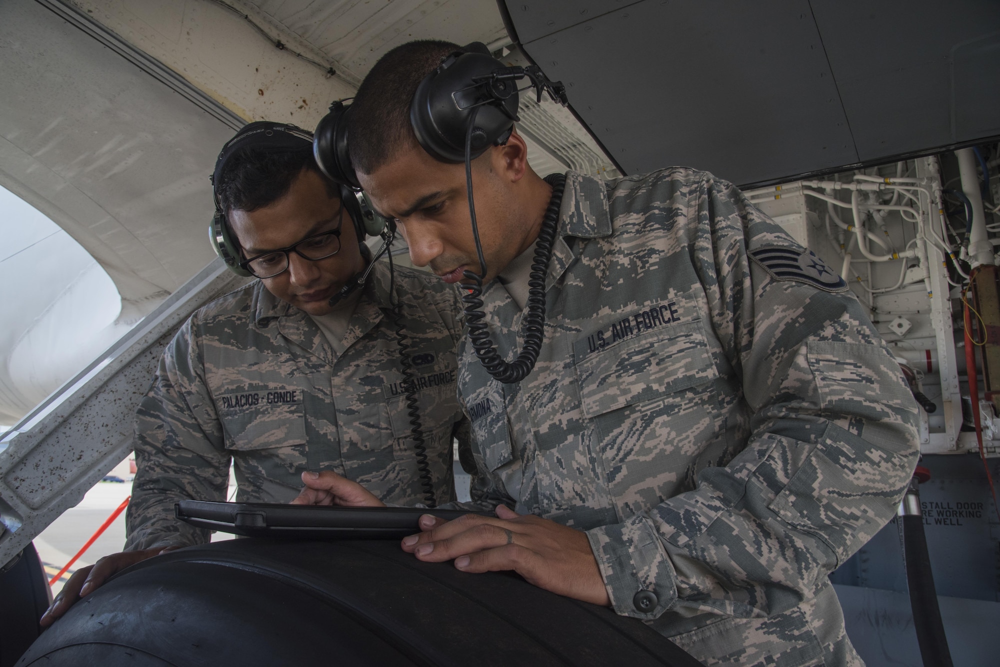 Staff Sergeant Jonathan Carmona, crew chief (right), reviews a technical order with Senior Airman Jonathan Palascios-Conde, crew chief (left), on the 108th Wing flightline at Joint Base McGuire-Dix-Lakehurst, N.J., Sept. 20, 2017. The maintainers, are refueling a KC-135 in preparation of an upcoming mission. (U.S. Air National Guard photo by Staff Sgt. Ross A. Whitley/Released)