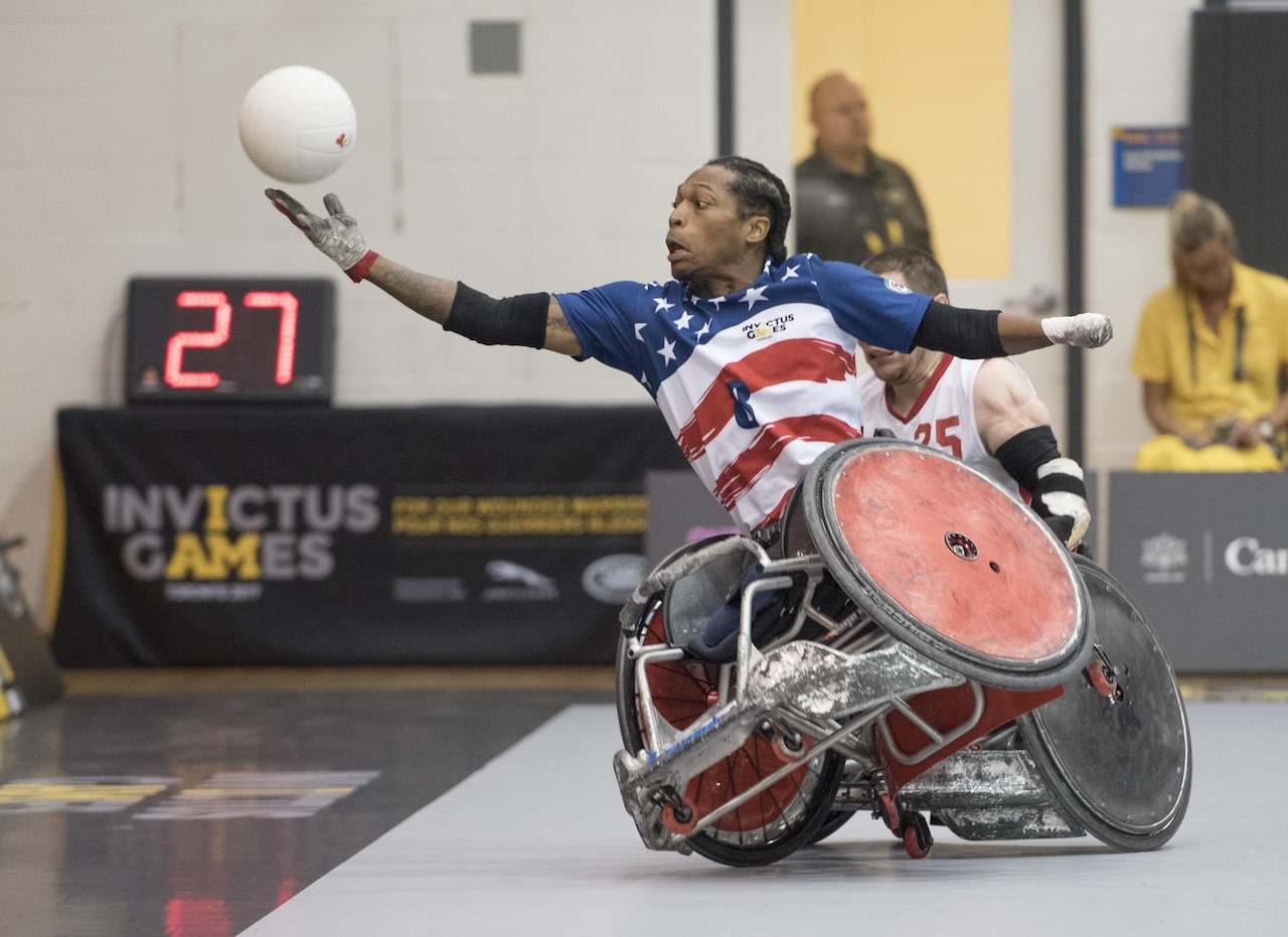 Anthony McDaniel, a Marine Corps veteran, reaches for a ball during a wheelchair rugby game against Italy during the 2017 Invictus Games