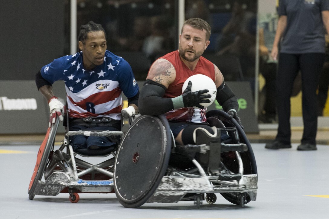 Team U.K.'s Stuart Robinson, right, tries to pull away from U.S. team member Anthony McDaniel in a wheelchair rugby game during the 2017 Invictus Games