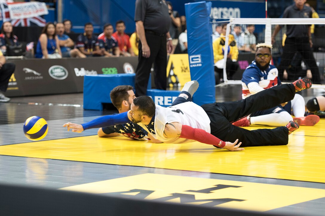 Marine Corps veteran Gunnery Sgt. Andrew Cordova dives for a ball during the bronze medal match against team Denmark in sitting volleyball.