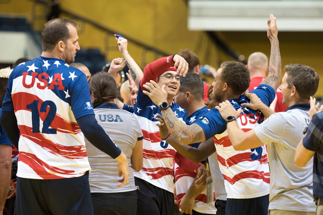 U.S. team members celebrate after winning the bronze medal against the Danish team in sitting volleyball.