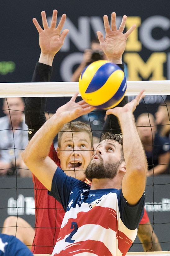 U.S. Army veteran Stefan Leroy sets a ball during the bronze medal match against the Danish team in sitting volleyball.