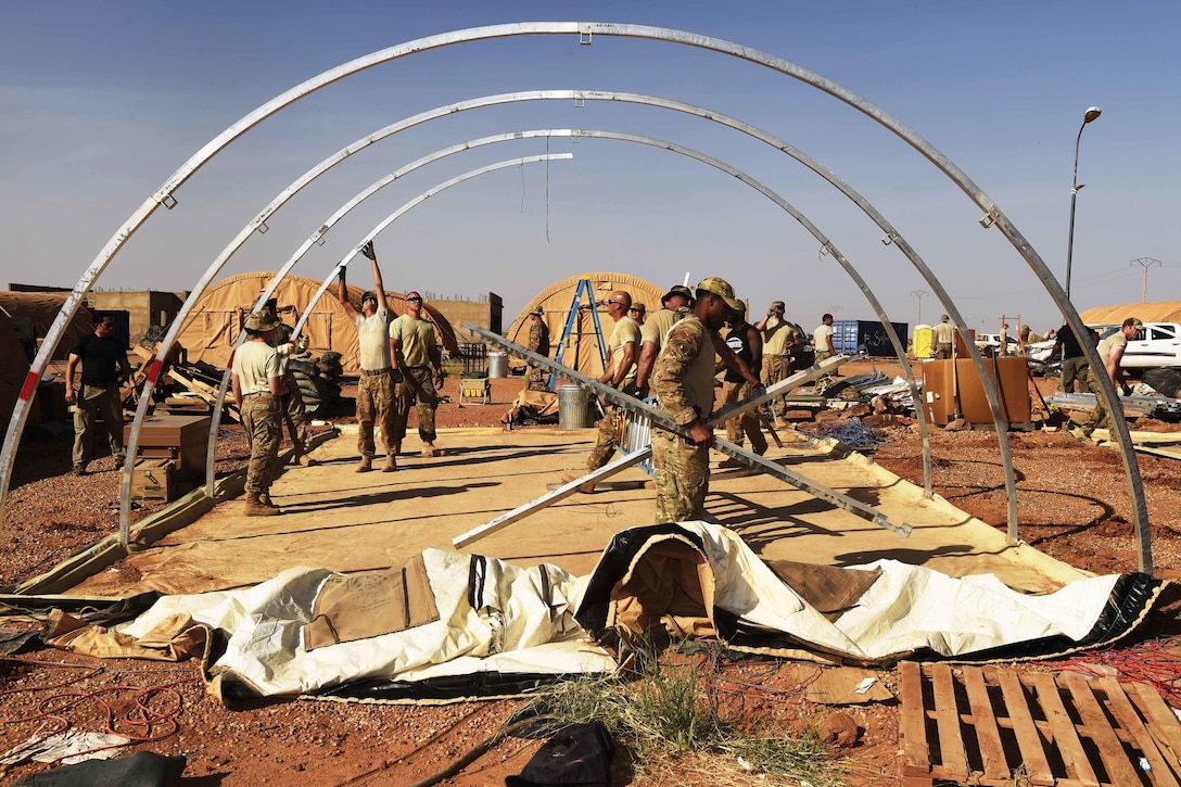 Airmen and soldiers take down tents.