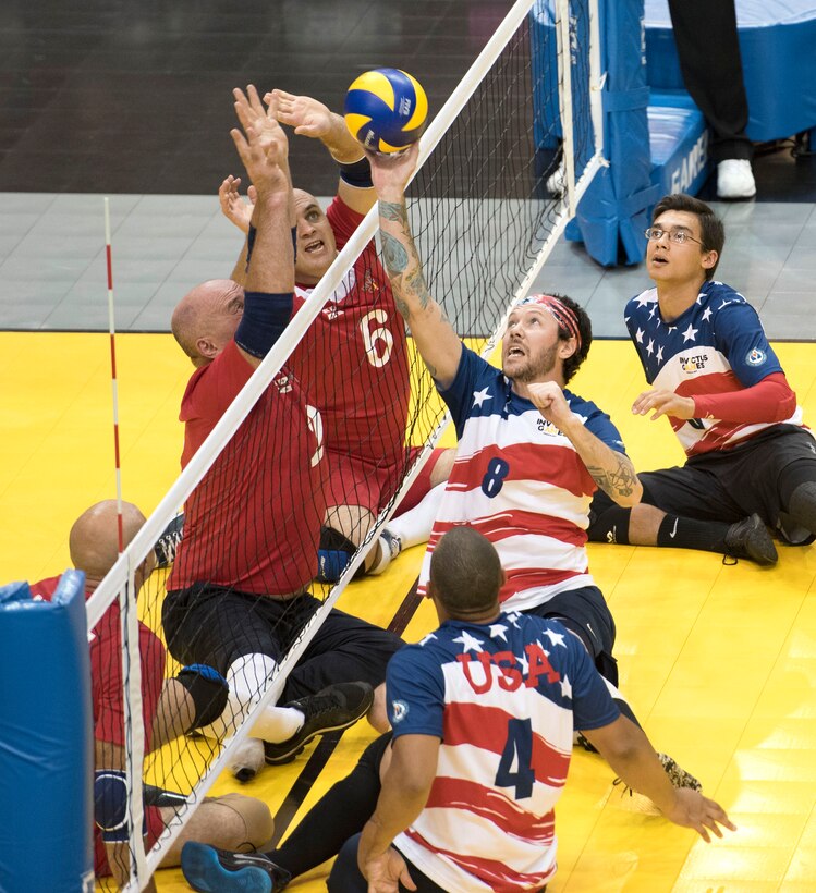 A U.S. team member returns a volley against Denmark in sitting volleyball