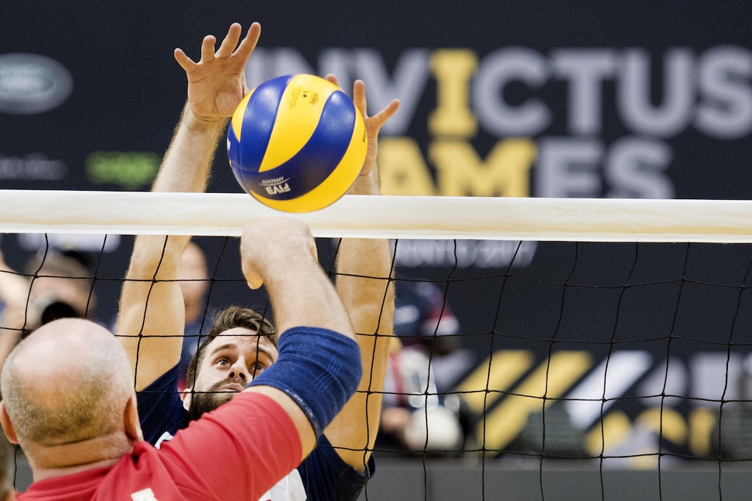 A U.S. team member blocks a spike against Denmark in sitting volleyball