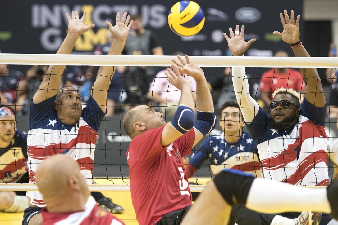 The U.S. team prepares to block a return by Denmark in sitting volleyball