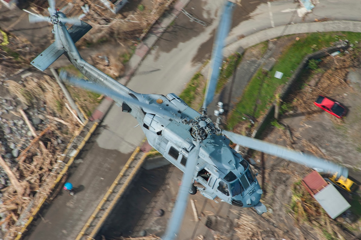 An MH-60S Sea Hawk helicopter flies over the island of Dominica during U.S. citizen evacuations and humanitarian relief following the landfall of Hurricane Maria.