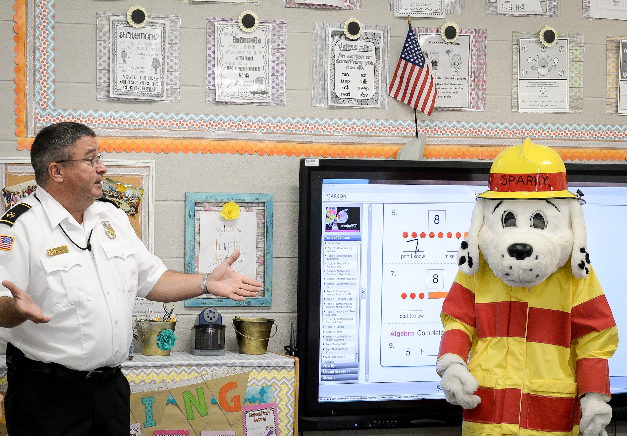 Peter J. Delillo, 14th Civil Engineer Squadron fire inspector, and Sparky the fire dog visit a first grade classroom at Caledonia Elementary School Sept. 26, 2017, in Caledonia, Mississippi. Fire and emergency service members from Columbus Air Force Base, Mississippi, went classroom to classroom at the elementary school and talked to students about the importance of having an evacuation plan and knowing their addresses amongst other things. (U.S. Air Force photo by Staff Sgt. Christopher Gross)