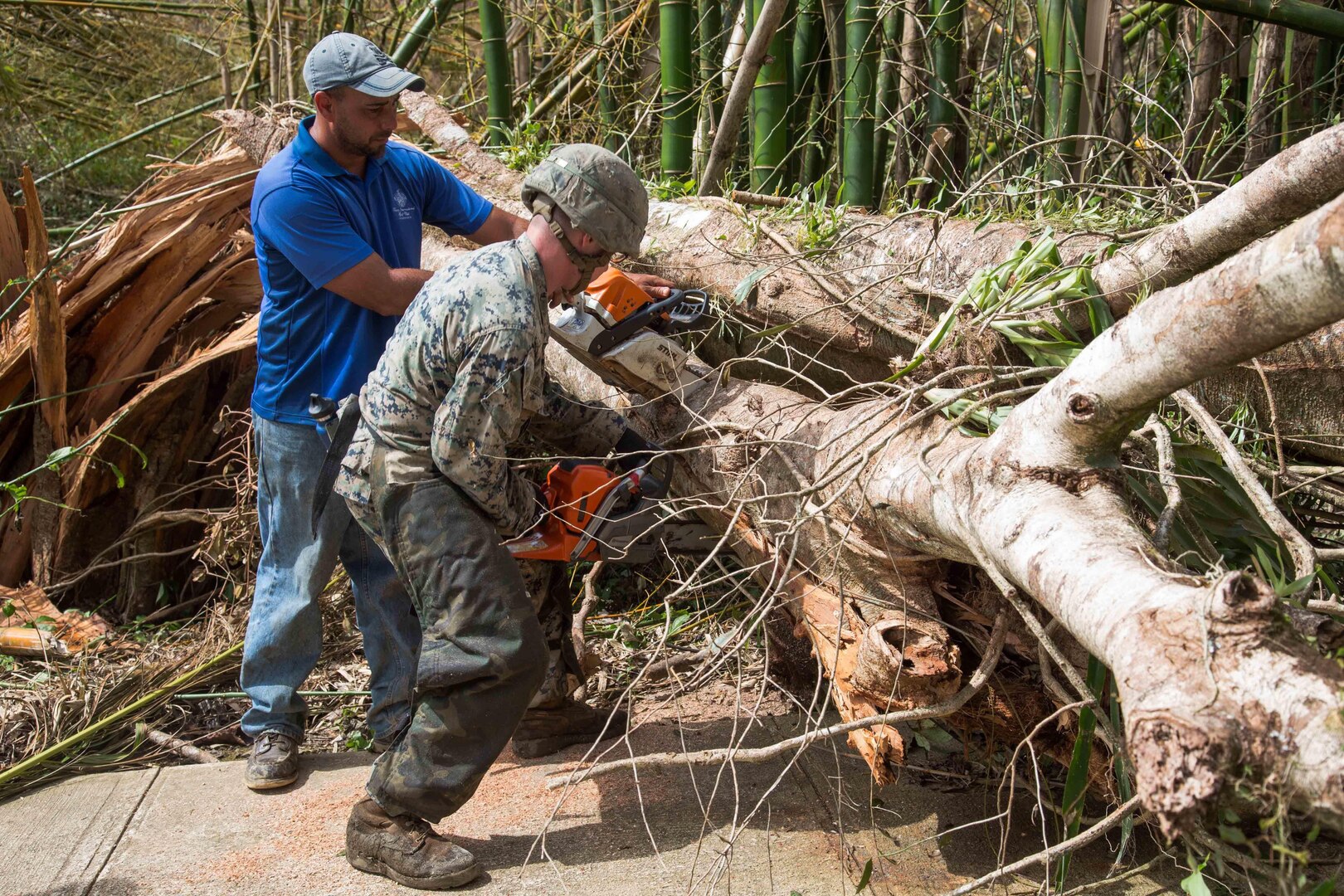 A Marine and resident work together to clear the main road.