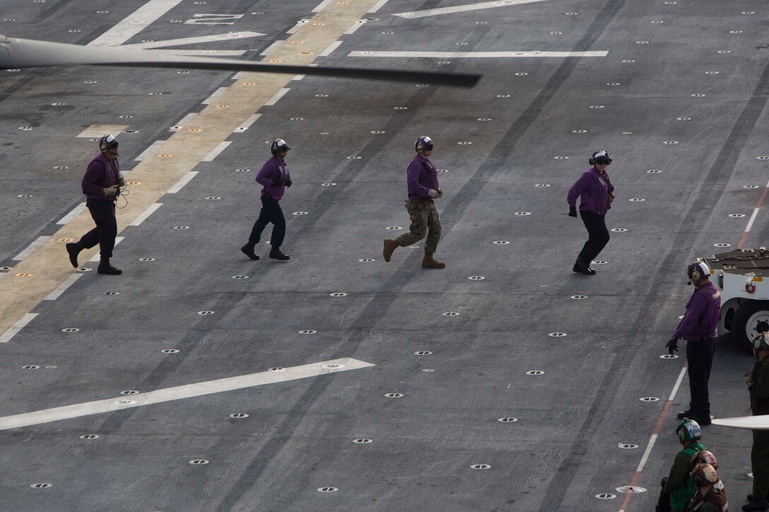 Sailors clear the flight deck on the USS Kearsarge.